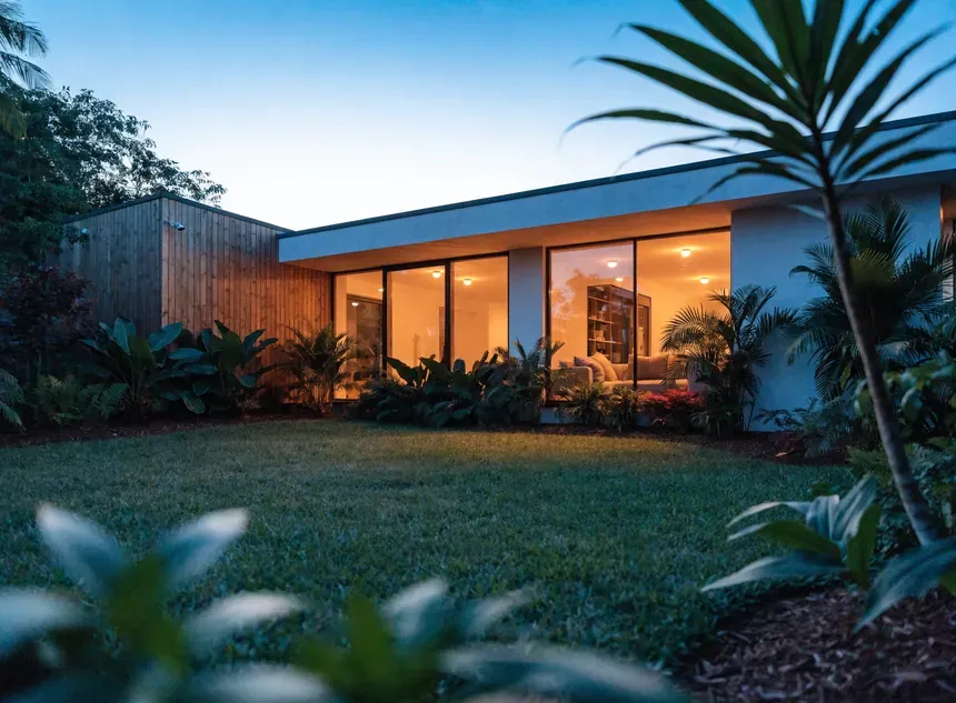 Casa térrea com jardim ao anoitecer. Imagem ilustrativa.